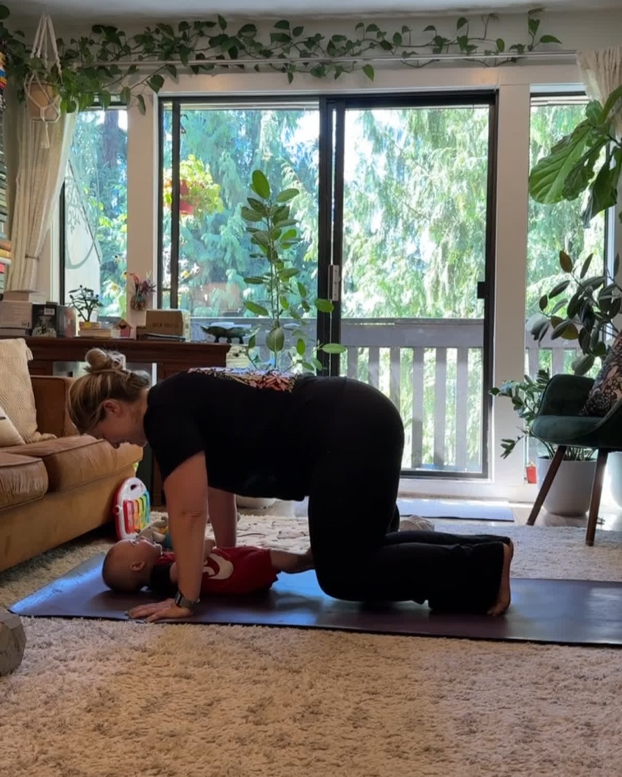 Mom doing a postpartum core exercise at home with her baby